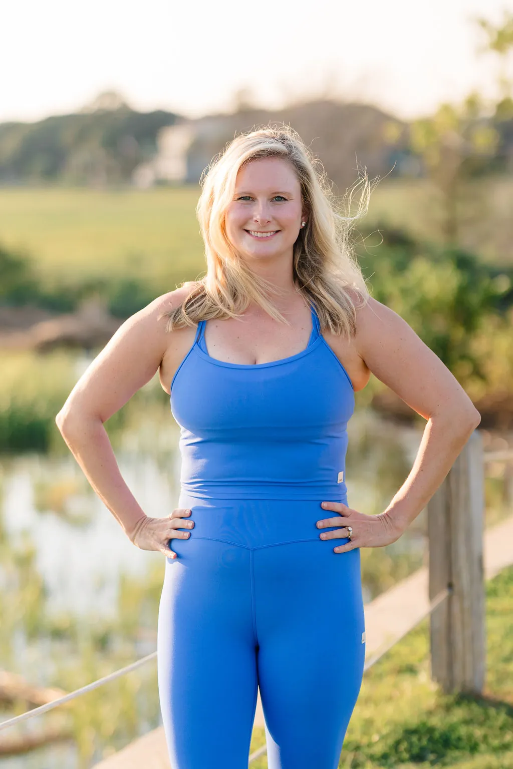 Coastal Sculpt co-founder smiling in a periwinkle set by the marsh
