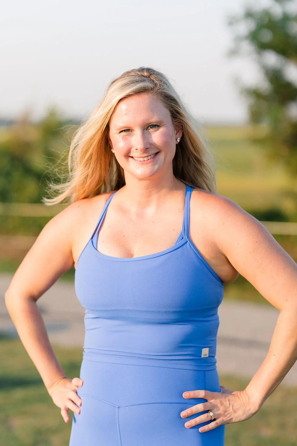 Maggie smiling with hands on her hips in a periwinkle set