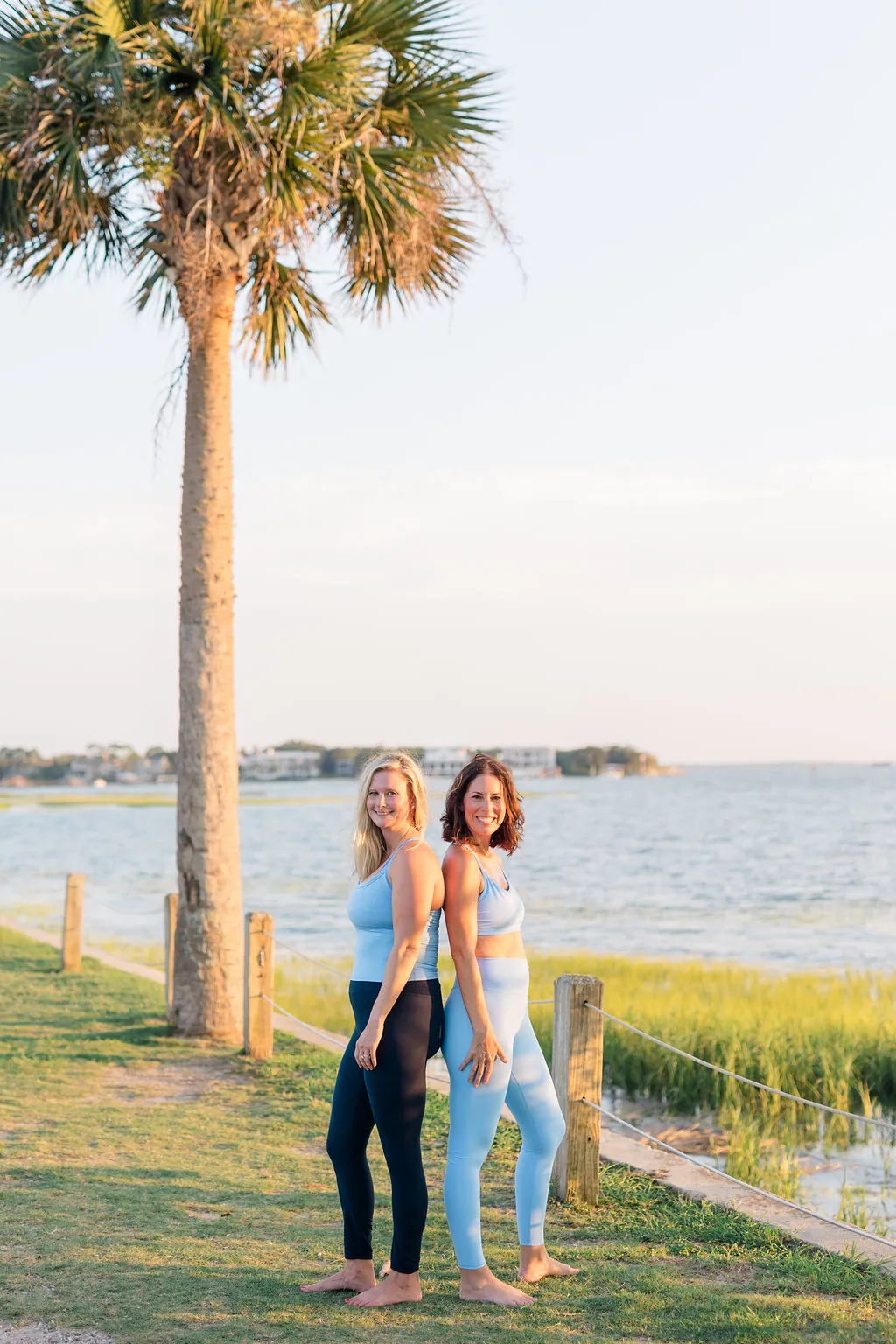 The founders arm in arm beneath a palmetto by the water